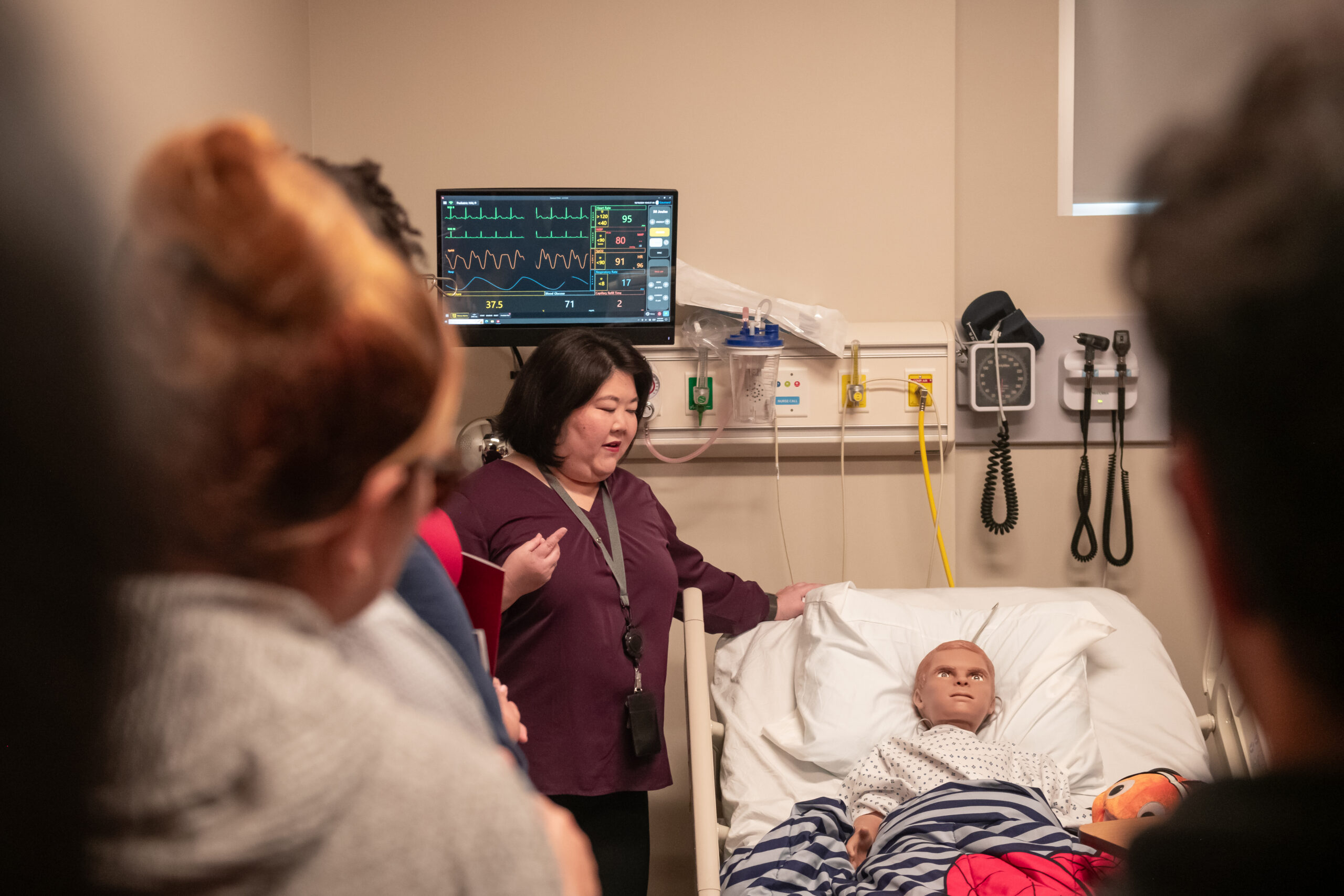 woman with child manikin in hospital bed