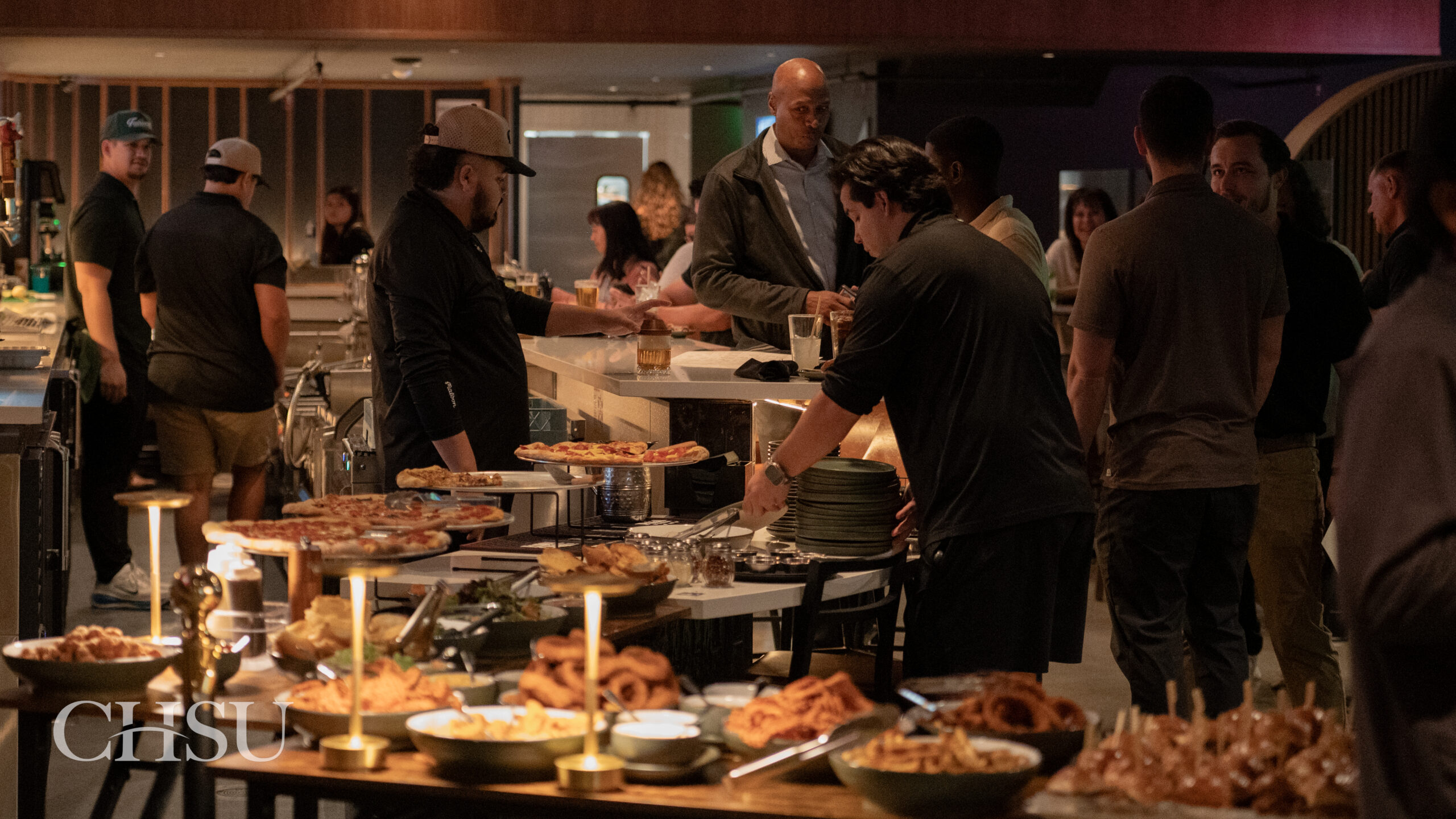 a group of people eating appetizers at the CHSU Sip and Swing Event