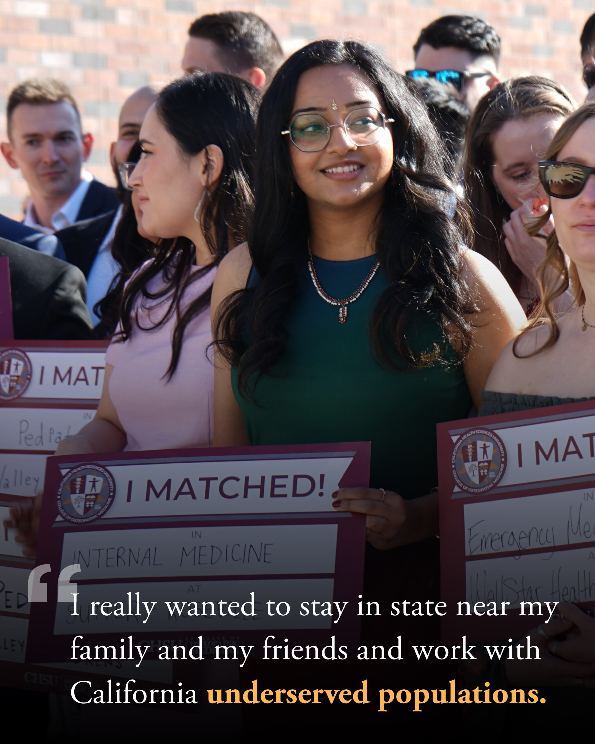 medical student holding I Matched sign with other students in background