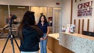 student interview by news reporter with camera on tri-pod