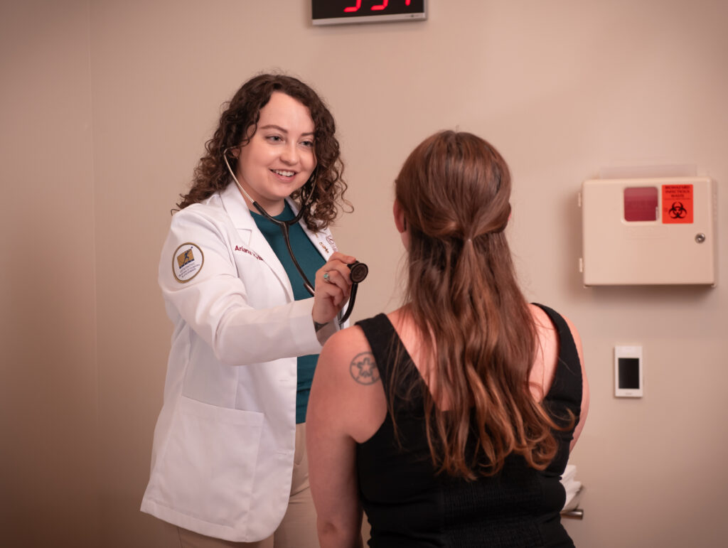 medical student with stethoscope and standardized patient in office