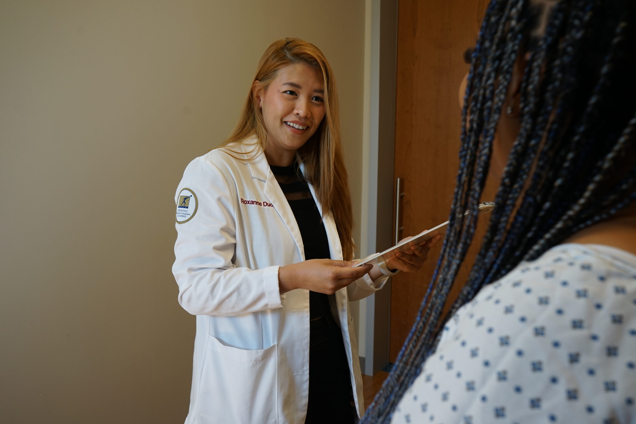 medical student with standardized patient in office