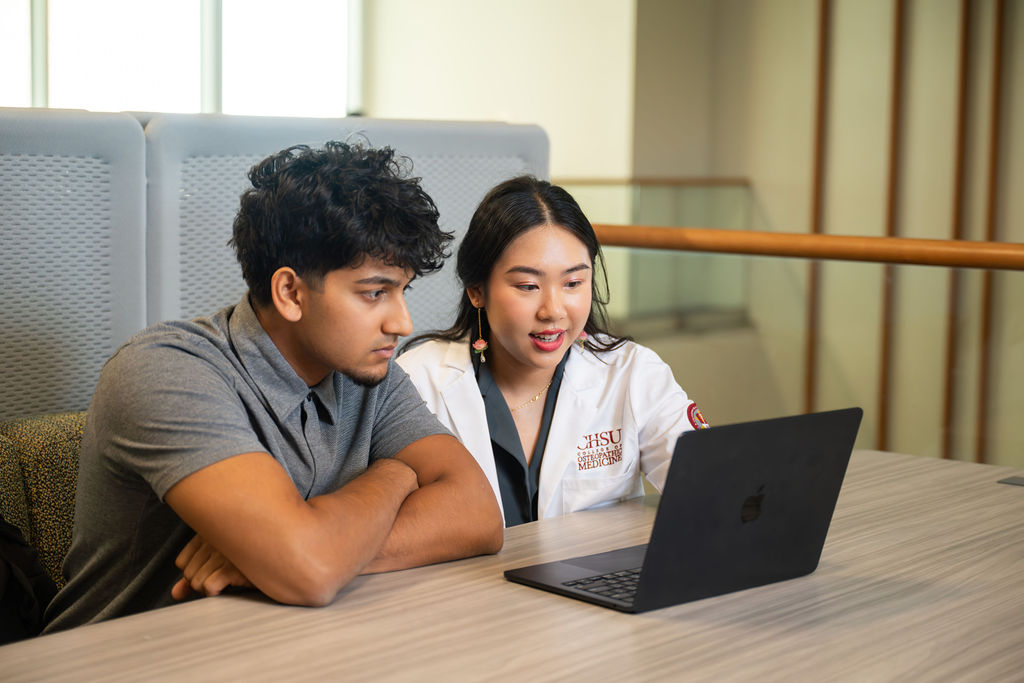 two students looking at laptop
