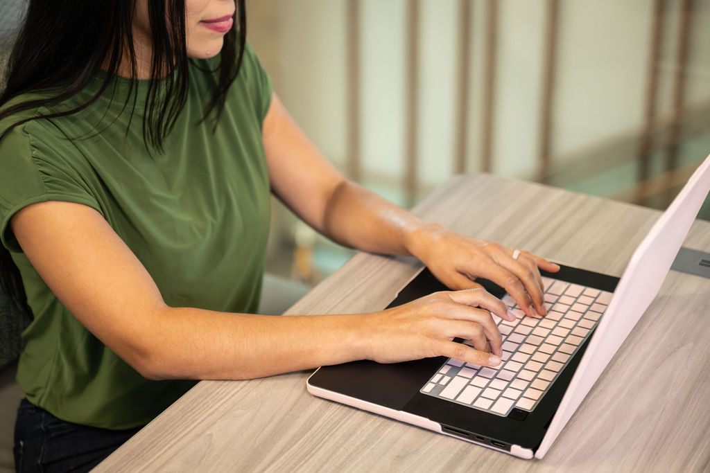 student typing on laptop