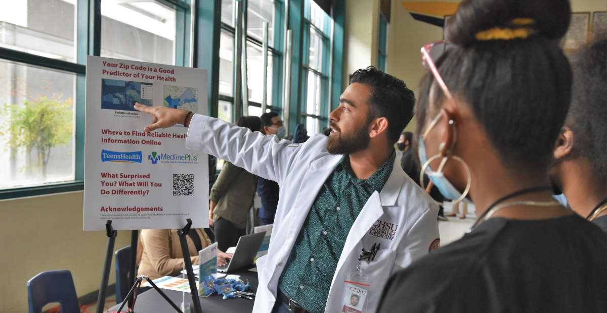 Student doctor pointing at poster board