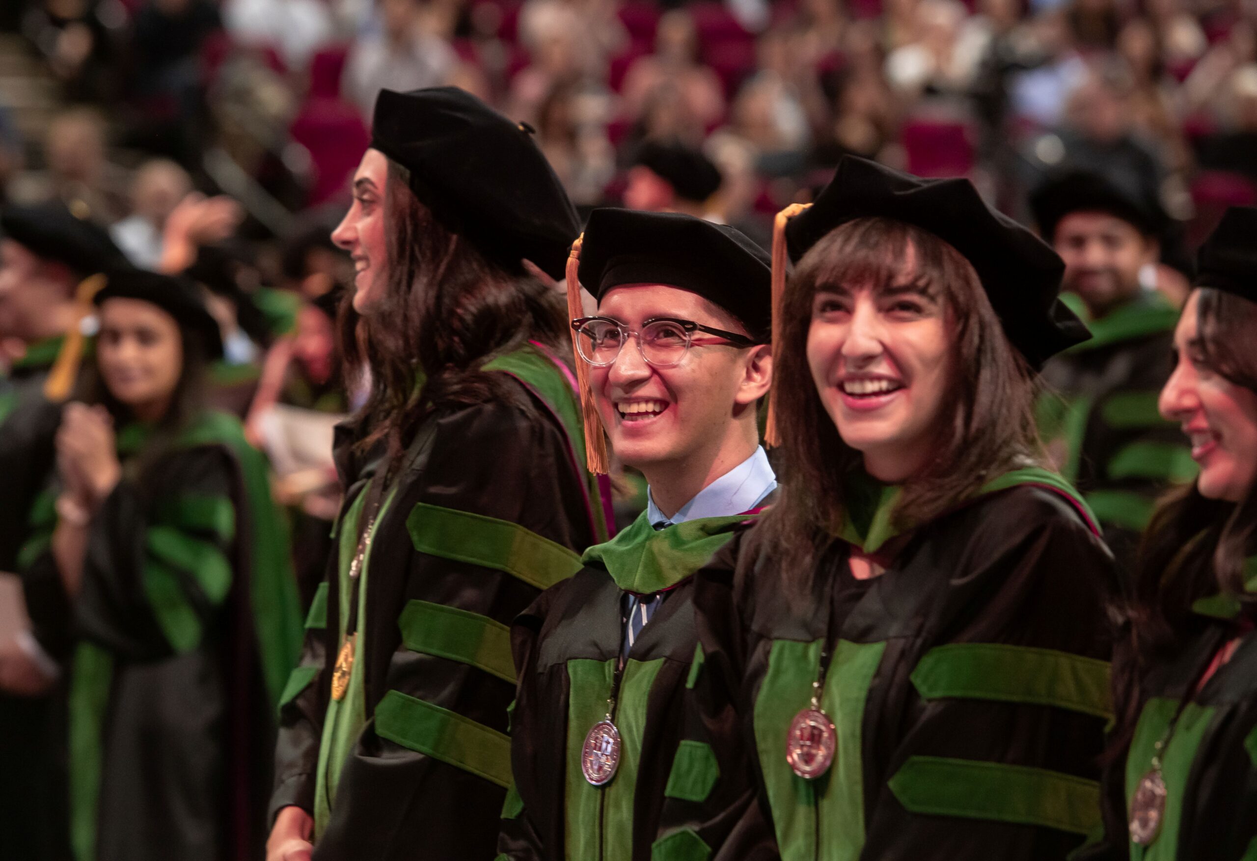 medical student graduates in regalia standing at Commencement