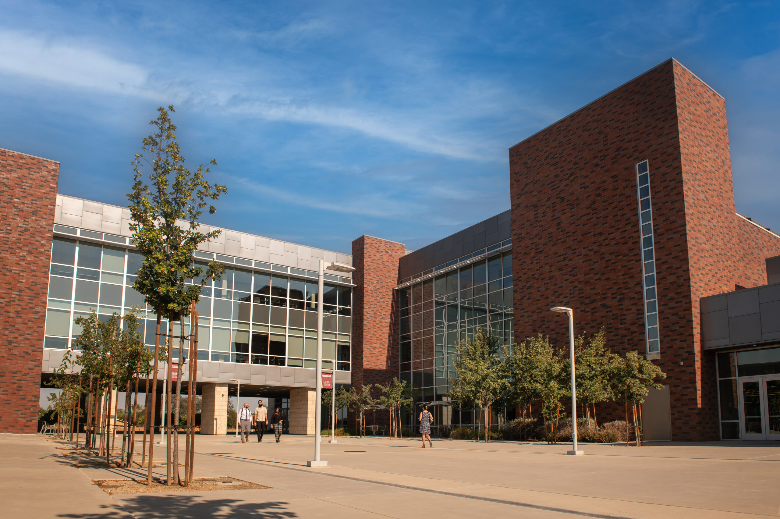 people walking in courtyard with building behind 