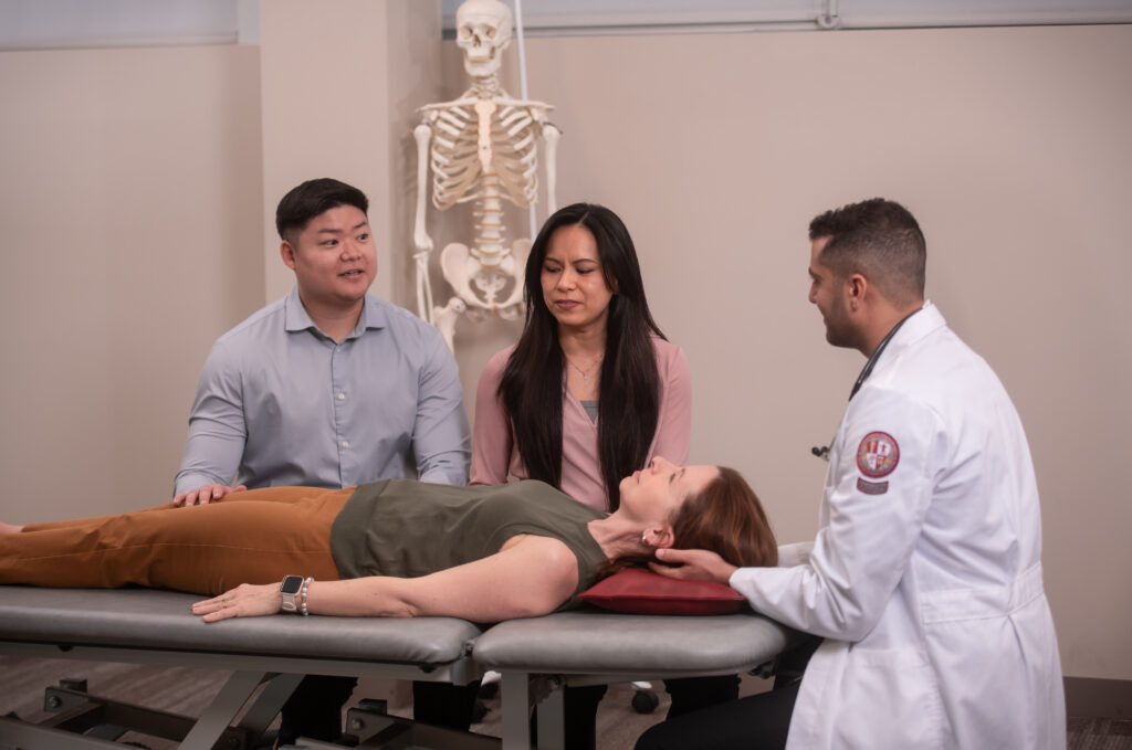 faculty and students with patient in OMM lab