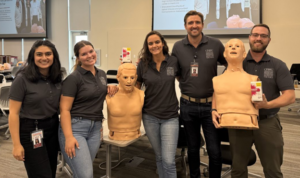 students pose with training manikins