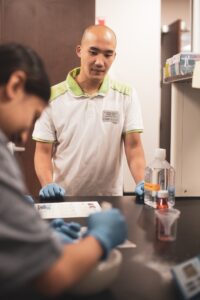 Man watching student in a lab